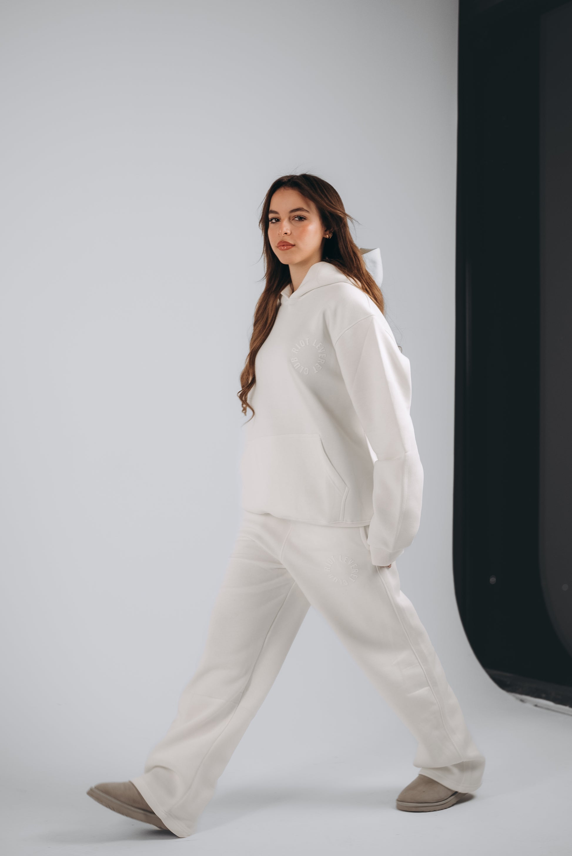 The model wears off-white relaxed-fit sweatpants paired with an oversized hoodie made from premium fleece fabric, designed for effortless comfort and minimalist style.